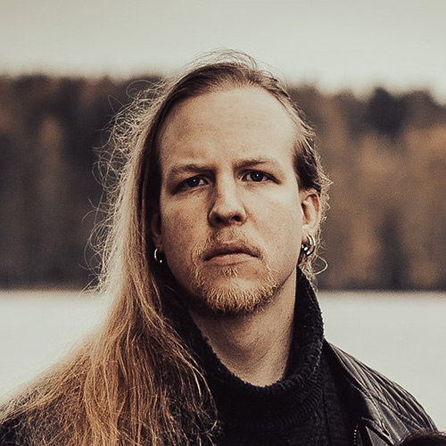 Artistic, sepia-toned portrait of Miikka, in front of a background full of trees and snow.