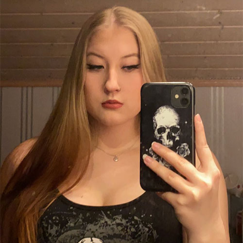 Mirror selfie of Milla holding her skull case-covered phone.