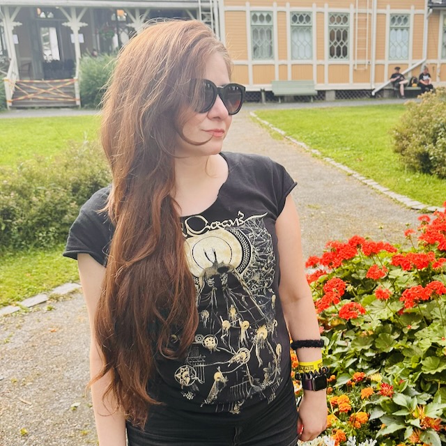 Nadya is standing in front of a yellow building.