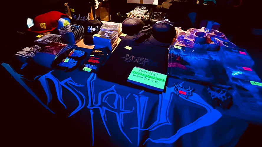 Kalmah's, Mors Subita's, and Suotana's t-shirts, hats, patches, CDs and vinyls neatly displayed on a table.