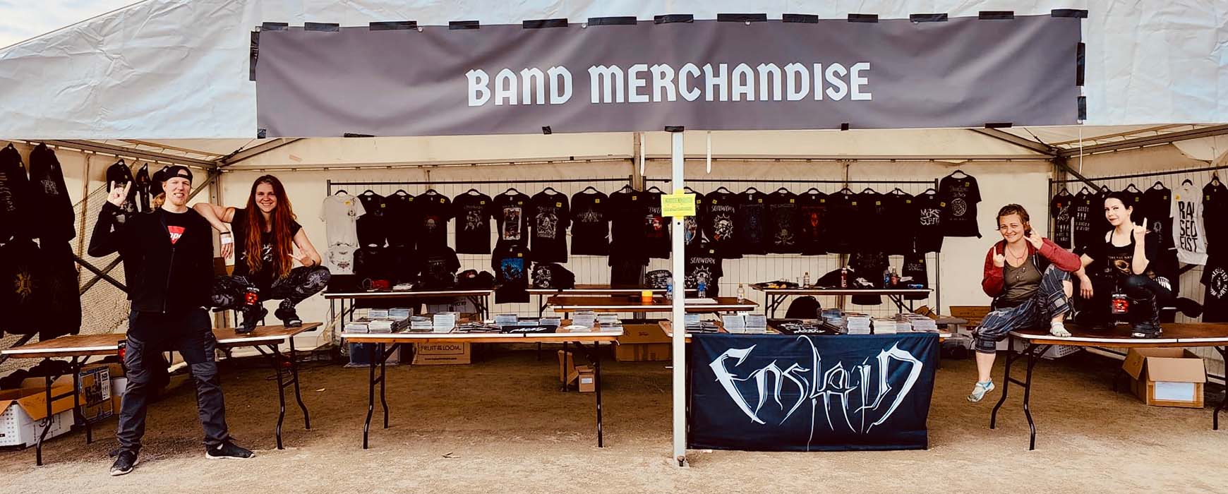 Chrissy, Miikka, Amy and Janetta enthusiastically flashing the horns in a large merchandise tent at the Metal Capital festival.