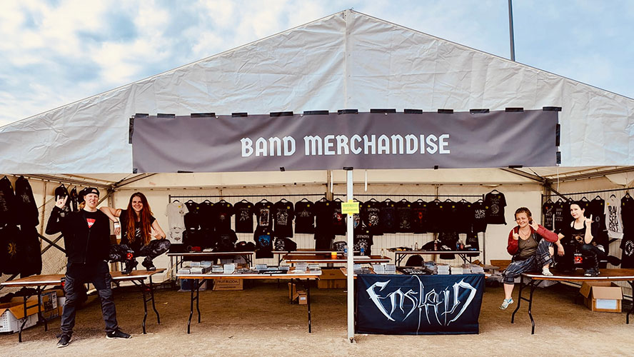 Chrissy, Miikka, Amy and Janetta enthusiastically flashing the horns in a large merchandise tent at The Metal Capital festival.